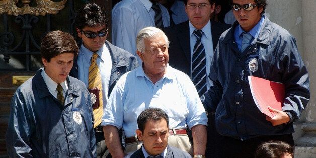 FILE - In this Jan. 28, 2005 file photo, retired Gen. Manuel Contreras, center, who headed the security service under former dictator Gen. Augusto Pinochet, leaves police headquarters in Santiago, Chile. The former chief of the feared spy agency responsible for kidnapping, torturing and killing thousands during Chileâs military dictatorship accumulated 500 years in prison sentences on May 20, 2015. The 86-year-old has been serving a combined sentence for crimes against humanity. (AP Photo, File) CHILE OUT - NO USAR EN CHILE