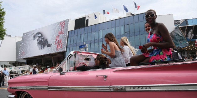 Girls drive on the Croisette in a Chevrolet Impala few hours prior the opening of the 66th edition of the Cannes Film Festival in Cannes on May 15, 2013. AFP PHOTO / LOIC VENANCE (Photo credit should read LOIC VENANCE/AFP/Getty Images)