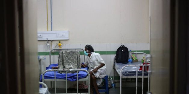 An attendant covers his face with a mask and sits beside a patient at the swine flu ward of Gandhi Hospital in Hyderabad, in the southern Indian state of Telangana, Friday, Feb. 20, 2015. Health authorities were working to ensure remote hospitals in India had adequate medical supplies for a flu outbreak that has claimed more than 700 lives in 10 weeks. More than 11,000 cases have been reported since mid-December with most of the cases being reported from Rajasthan, Gujarat, Maharashtra, Telangana and Madhya Pradesh states. Although it was being referred to as swine flu, doctors say it is a variant of the H1N1 pandemic influenza. (AP Photo/Mahesh Kumar A.)