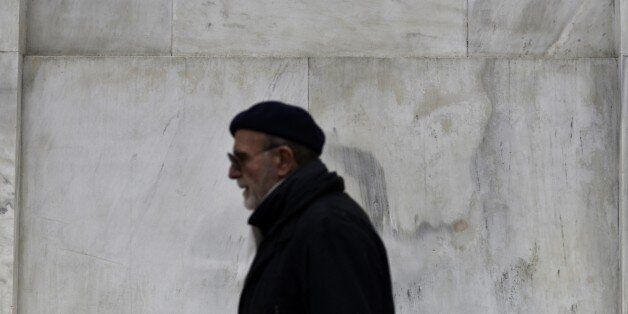 A man walks outside the headquarters of the Bank of Greece in Athens on February, 18, 2015. Greece was expected today to make its first formal bid to resolve the bailout crisis by asking for a six-month loan extension, but the idea was shot down in advance by EU paymaster Germany. AFP PHOTO / ARIS MESSINIS (Photo credit should read ARIS MESSINIS/AFP/Getty Images)