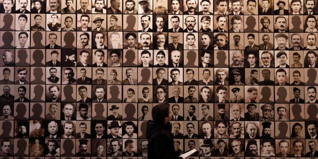 In this photo taken on Saturday, March 21, 2015, a young boy looks at portraits of victims at the Holocaust Museum in the town of Kalavryta, western Greece. Greek Defence Minister Panos Kamenos said Monday, April 5, that the country has obtained