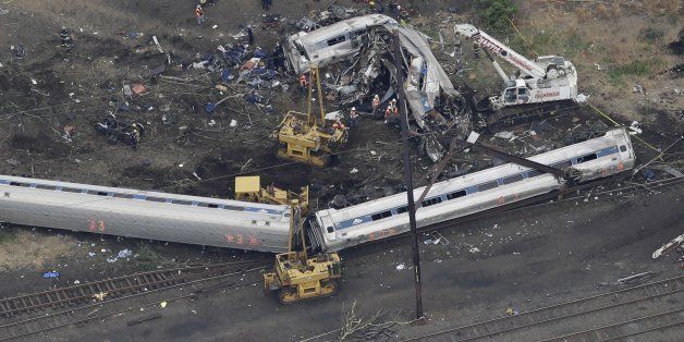 In this aerial photo, emergency personnel work at the scene of a deadly train wreck, Wednesday, May 13, 2015, in Philadelphia. Federal investigators arrived Wednesday to determine why an Amtrak train jumped the tracks in a wreck that killed at least six people, and injured dozens. (AP Photo/Patrick Semansky)