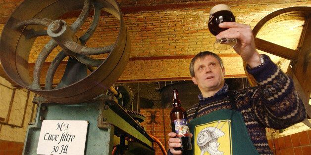 Francois Tonglet, owner of the Caracole brewery, holds up a glass of his own brew in Falmignoul, Belgium, March 9, 2004. Tonglet, along with co-owner Jean-Pierre Debras, produce nearly 39,000 gallons of beer each year in their small brewery with buildings dating back to the 1820's. (AP Photo/Geert Vanden Wijngaert)
