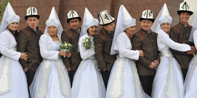 Kyrgyz couples take part in a mass wedding ceremony in the capital Bishkek on November 13, 2012. Thirty-five couples took part in the mass wedding sponsored by a state company. AFP PHOTO / VYACHESLAV OSELEDKO (Photo credit should read VYACHESLAV OSELEDKO/AFP/Getty Images)
