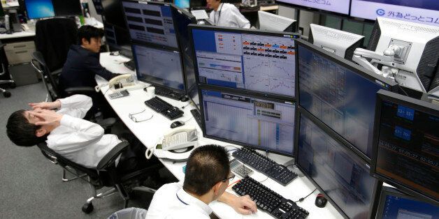 Money traders work at a computer terminal at a foreign exchange brokerage in Tokyo, Friday, Dec. 5, 2014. The dollar gained to 119.89 yen from 119.76 yen. The euro fell to $1.2384 from $1.2386. (AP Photo/Shizuo Kambayashi)