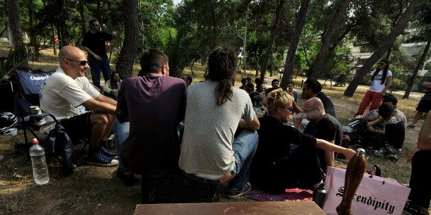 TO GO WITH AFP STORY by Roland Lloyd Parry: Patricipants of a time-exchange network stage a pic-nic for new members at an Athens park on May 27, 2012 to indroduce an online exchange where members swap services, counting the cost not in euros, but in hours. More than 1,000 people are registered on the Athens time bank, of which around 200 active members regularly use it to give and receive services. Time-banking and other forms of bartering are on the rise in Greece and other crisis-hit countries such as Spain, as people come to grips with lower salaries, pensions and job prospects. AFP PHOTO/ LOUISA GOULIAMAKI (Photo credit should read LOUISA GOULIAMAKI/AFP/GettyImages)
