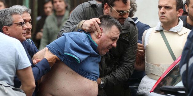 The alleged shooter is taken into custody after a shooting spree, in Naples, Italy, 15 May 2015. Italian police say a man opened fire with a pump-action rifle in a Naples suburb, killing first his brother and sister-in-law at home, then killing two other persons and wounding six as he shot from a balcony. The police said the man, a 48-year-old nurse, surrendered to officers and was being questioned Friday evening at Naples police headquarters. (Cesare Abbate/ANSA via AP) ITALY OUT