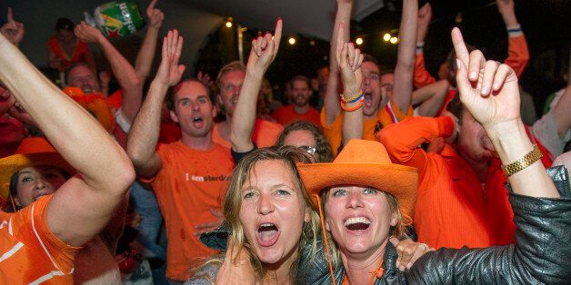 People celebrate as they watch the Dutch team win after penalties in the World Cup quarter finals soccer match between the Netherlands and Costa Rica at Strandzuid in Amsterdam, Saturday, July 5, 2014. (AP Photo/Patrick Post)