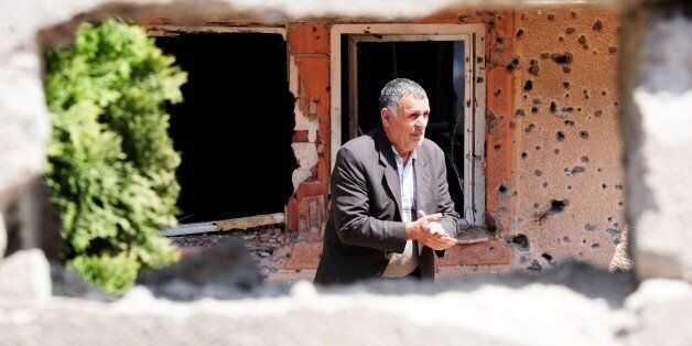 A man walks through a destroyed house in Kumanovo on May 12, 2015. Special police units pulled out of the northern Macedonian town early on May 11 where 22 people, including eight officers, were killed over the weekend in worst violence in the country since its 2001 inter-ethnic conflict. Thirty men were later charged with terror offences. AFP PHOTO / ROBERT ATANASOVSKI (Photo credit should read ROBERT ATANASOVSKI/AFP/Getty Images)