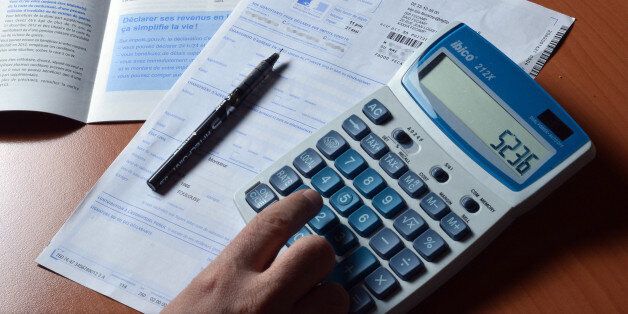 A person uses a calculator as he fills out a pre-filled tax declaration for the 2012 income tax on March 31, 2013 in Paris. AFP PHOTO / MIGUEL MEDINA (Photo credit should read MIGUEL MEDINA/AFP/Getty Images)