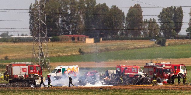 Emergency services personnel work at the scene after a plane crash near the Seville airport, in Spain, Saturday, May 9, 2015. A military transport plane crashed near southwestern Seville airport Saturday, killing its crew, Spain's prime minister said. It is unclear if any others were injured. Mariano Rajoy said up to 10 crew members were aboard the brand new Airbus A400M aircraft that was undergoing flight trials at the airport. (AP Photo/Miguel Angel Morenatti)