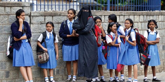 A veiled Muslim school girl stands with fellow students at the end of the day outside a school in Bangalore, India, Tuesday, June 18, 2013. (AP Photo/Aijaz Rahi)