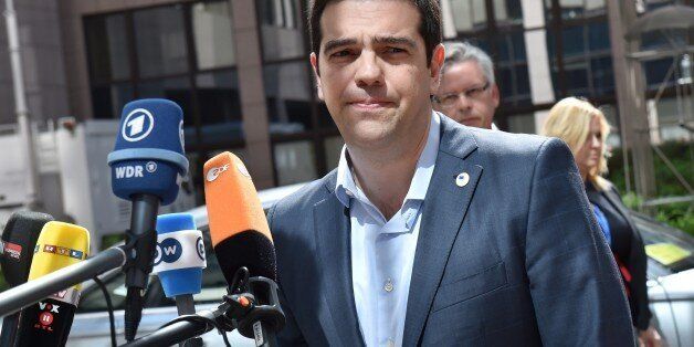 Greece's Prime minister Alexis Tsipras addresses reporters upon his arrival at the European Council headquarters for an extraordinary summit of European leaders to deal with a worsening migration crisis, on April 23, 2015 in Brussels. European leaders gather on April 23 to consider military action, at an extraordinary summit to deal with a worsening migration crisis after a series of deadly shipwrecks in the Mediterranean. AFP PHOTO / PHILIPPE HUGUEN (Photo credit should read PHILIPPE