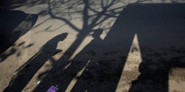 The shadow of an Indian couple is cast on a road at the bus stop where the victim of a deadly gang rape had boarded the bus on Dec. 16, 2012, in New Delhi, India, Wednesday, March 4, 2015. When one of the four men sentenced to death for the high-profile gang rape of the woman in 2012 was quoted in a new documentary as saying
