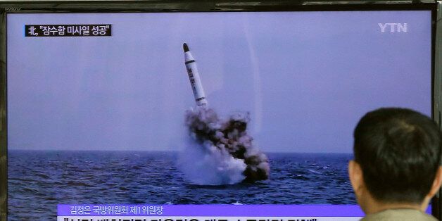 A South Korean man watches a TV news program showing an image published in North Korea's Rodong Sinmun newspaper of North Korea's ballistic missile believed to have been launched from underwater, at Seoul Railway station in Seoul, South Korea, Saturday, May 9, 2015. North Korea said Saturday it has successfully test-fired a newly developed ballistic missile from a submarine in what would be the latest display of the country's advancing military capability. The letters on the screen read