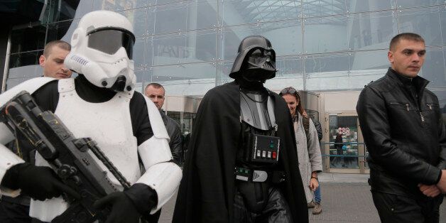 Darth Vader, leader of Ukraine's Internet Party, surrounded by guards passes by a shop in Kiev, Ukraine, Wednesday, Oct. 22, 2014. Vader, who had his name legally changed by deed poll, is campaigning for the Oct. 26 parliamentary elections on a platform of promoting e-government and increasing financial transparency. (AP Photo/Efrem Lukatsky)