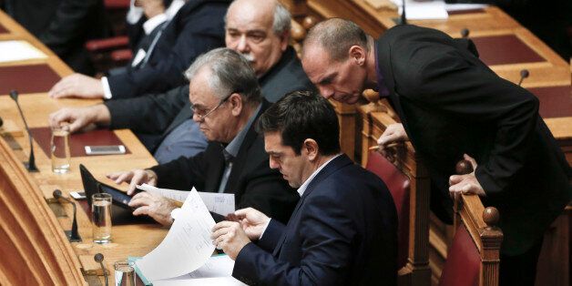 Greek Minister Alexis Tsipras front and his Finance Minister Yanis Varoufakis, right, look on papers during the vote for the president of Greece's parliament in Athens, on Friday, Feb. 6, 2015. Barely 10 days after radical left-wing Syriza was swept to power in Athens, analysts expect a compromise over Greece's debts to emerge, allowing it to remain a member of the 19-country eurozone. The finance ministers of the 19-country eurozone are to meet at a special meeting Wednesday on the eve of a summit of European Union leaders to discuss Greeceâs debts. (AP Photo/Petros Giannakouris )