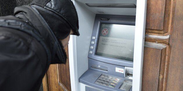 A man stands in front an ATM machine which is out of order, on November 26, 2014 in the eastern Ukrainian city of Donetsk. No automated teller machines were working and most shops didn't accept payment by credit cards in Donetsk after Kiev asked for the suspension of banking activities in the eastern area controlled by pro-russian separatists. AFP PHOTO / ERIC FEFERBERG (Photo credit should read ERIC FEFERBERG/AFP/Getty Images)