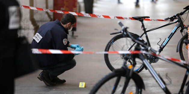 A police officer collects clues after an attacker with a knife hidden in his bag attacked three soldiers on an anti-terror patrol in front of a Jewish community center in Nice, southern France, Tuesday Feb.3, 2015 . France has been on high alert since the attacks in the Paris region by three Islamic extremists that left 20 people dead, including the gunmen. More than 10,000 soldiers have been deployed around the country to protect sensitive locations, including major shopping areas, synagogues, mosques and transit hubs. (AP Photo/Lionel Cironneau)