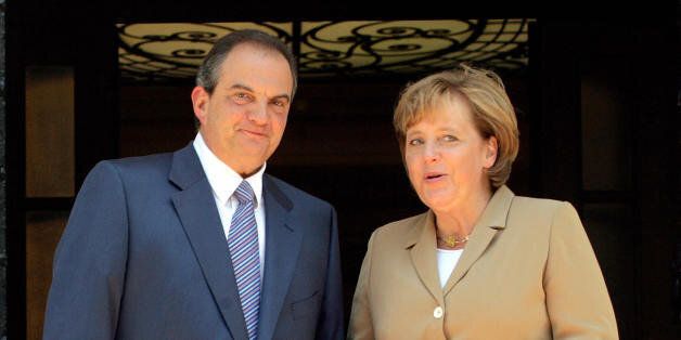 Athens, GREECE: Greek Prime Minister Kostas Karamanlis (R) greets German Chancellor Angela Merkel upon her arrival at the Maximon Mansion in Athens, 20 July 2007. Angela Merkel is on a one-day visit to Greece. AFP PHOTO/Takis Takatos (Photo credit should read TAKIS TAKATOS/AFP/Getty Images)