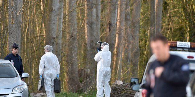 Forensics experts take photos near the site in the Dubrulle forest where the dead body of an 8-year-old girl was found near the port of Calais, northern France, on April 15, 2015. A suspect of Polish nationality was placed in custody on April 15 by the judicial police of Coquelles, near Calais, following the discovery in the afternoon of the body of an 8 year-old girl who was abducted earlier, a source close to the investigation said. AFP PHOTO / PHILIPPE HUGUEN (Photo credit should read
