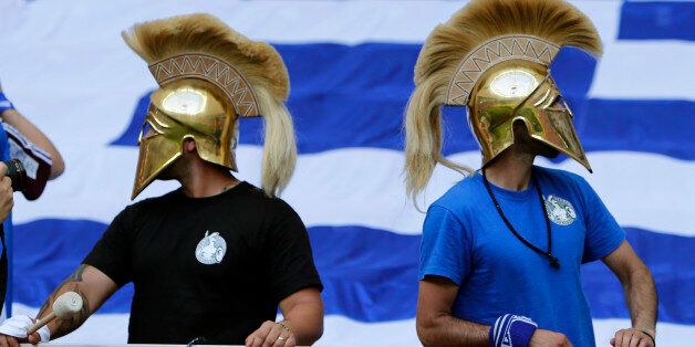 Fans wear mock ancient Greek helmets prior to the Euro 2012 soccer championship Group A match between Greece and Russia in Warsaw, Poland, Saturday, June 16, 2012. (AP Photo/Thanassis Stavrakis)