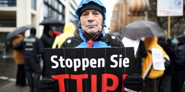 A protester holds up a sign, reading: 'Stop TTIP! (Transatlantic Trade and Investment Partnership)' as he demonstrates in front of the headquarters of Germany's Social Democratic Party SPD prior to a conference on Transatlantic Trading 'Transatlantic Free Trade - Opportunities and Risks' in Berlin on February 23, 2015. AFP PHOTO / TOBIAS SCHWARZ (Photo credit should read TOBIAS SCHWARZ/AFP/Getty Images)