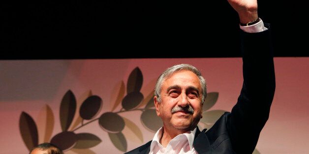 Turkish Cypriot newly elected leader Mustafa Akinci waves to his supporters after won the leadership election in Nicosia in the Turkish Cypriot breakaway north part of the divided island of Cyprus, Sunday, April 26, 2015. Akinci, a veteran politician with a strong track record of reaching out to rival Greek Cypriots, was elected as leader of the breakaway Turkish Cypriots in ethnically divided Cyprus. Akinci defeated hard-line incumbent Dervis Eroglu with 60.38 percent of the vote, preliminary official results showed. Turnout for Sunday's vote was just over 64 percent. (AP Photo/Petros Karadjias)
