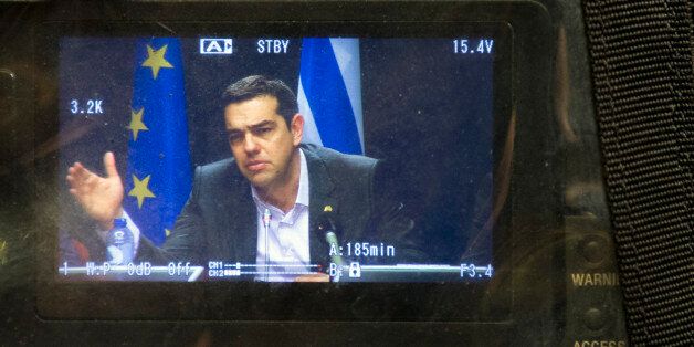 Greek Prime Minister Alexis Tsipras appears on a television monitor as he speaks during a press conference at an EU summit in Brussels on Friday, March 20, 2015. The European Union committed 2 billion euros ($2.15 billion) on Friday to help Athens deal with what even EU leaders now call the