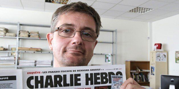 FILE - In this Sept.19, 2012 file photo, Stephane Charbonnier also known as Charb , the publishing director of the satyric weekly Charlie Hebdo, displays the front page of the newspaper as he poses for photographers in Paris. The late former editor of French weekly Charlie Hebdo takes on politicians, the media and