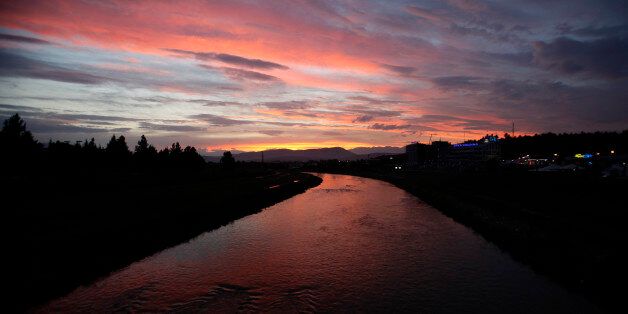 The sky, red from the sunset, casts its reflection in Vardar River in Skopje, Macedonia, after a heavy rain on Saturday, Sept. 13, 2014. The forecast predicts rainy weather with thunderstorms for the next few days in this Balkan country. (AP Photo/Boris Grdanoski)