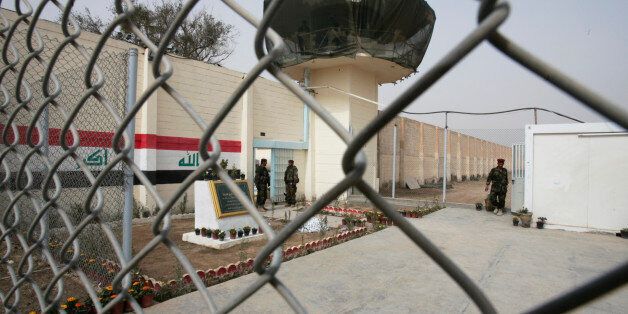 Guards stand at the entrance of a renovated Abu Ghraib prison, now renamed Baghdad Central Prison in Baghdad, Iraq, Saturday, Feb. 21, 2009. Iraq has reopened the notorious Abu Ghraib prison west of Baghdad, but it has a new name and officials promise more humane treatment of prisoners. The compound has come to symbolize American abuses after photos released in 2004 showed U.S. soldiers sexually humiliating inmates there.(AP Photo/Karim Kadim)