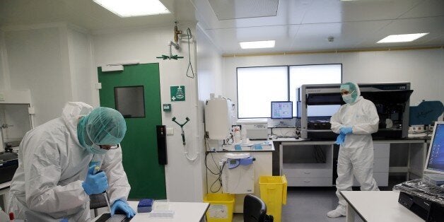 Forensic scientists of the Criminal Research Institute of the National Gendarmerie (IRCGN), collect DNA taken from the body parts of victims of the crash of a A320 Germanwings jetliner, in Pontoise, outside Paris, on March 30, 2015. The process of identifying the victims of Germanwings crash has now entered its active phase, but the families will still have to wait months to find out if their loved ones are among the bodies found. AFP PHOTO/POOL CHRISTOPHE ENA (Photo credit should read CHRISTOPHE ENA/AFP/Getty Images)