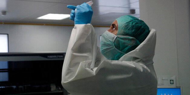 A forensic scientist of the Criminal Research Institute of the National Gendarmerie (IRCGN), collects DNA taken from the body parts of people involved in the crash of Germanwings jetliner, in Pontoise, outside Paris, France, Monday, March 30, 2015. The process of identifying the victims of Germanwings crash has now entered its active phase, but the families will still have to wait months to find out if their loved ones are among the bodies found. (AP Photo/Christophe Ena, Pool)