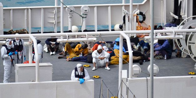 Survivors of the smuggler's boat that overturned off the coasts of Libya lie on the deck of the Italian Coast Guard ship Bruno Gregoretti, in Valletta's Grand Harbour, Monday, April 20 2015. A smuggler's boat crammed with hundreds of people overturned off Libya's coast on Saturday as rescuers approached, causing what could be the Mediterranean's deadliest known migrant tragedy and intensifying pressure on the European Union Sunday to finally meet demands for decisive action. So far rescuers saved 28 people a recovered 24 bodies. (AP Photo/Lino Azzopardi)