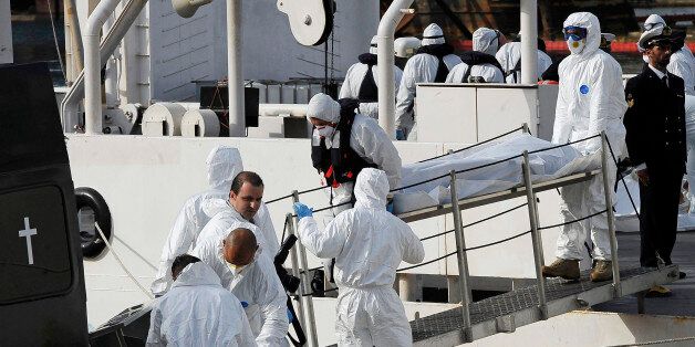Italian Coast Guard officers disembark the body of a dead migrant off the ship Bruno Gregoretti, in Valletta's Grand Harbour, Monday, April 20 2015. A smuggler's boat crammed with hundreds of people overturned off Libya's coast on Saturday as rescuers approached, causing what could be the Mediterranean's deadliest known migrant tragedy and intensifying pressure on the European Union Sunday to finally meet demands for decisive action. So far rescuers saved 28 people a recovered 24 bodies. (AP Photo/Lino Azzopardi)