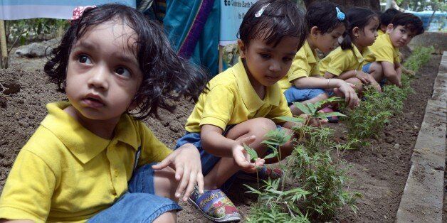 Young Indian schoolchildren participate in a tree planting programme on the occasion of Earth Day in Kolkata on April 22, 2015. Earth Day is observed each April 22, during which events are held worldwide to demonstrate support for environmental protection. AFP PHOTO / Dibyangshu SARKAR (Photo credit should read DIBYANGSHU SARKAR/AFP/Getty Images)