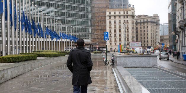 A man walks by EU flags at half-staff in front of EU headquarters in Brussels on Wednesday, March 25, 2015. The flags are at half-staff to remember the victims that died Tuesday in the Germanwings plane crash in the French Alps on the way from Barcelona, Spain to Duesseldorf in Germany. (AP Photo/Virginia Mayo)