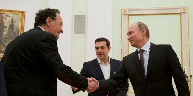 Russian President Vladimir Putin, right, shakes hands with Greece's energy and environment minister Panagiotis Lafazani, left, as visiting Greek Prime Minister Alexis Tsipras smiles at the background, in Moscow's Kremlin, Russia, Wednesday, April 8, 2015. Alexis Tsipras is in Russia on an official visit. (AP Photo/Alexander Zemlianichenko, Pool)
