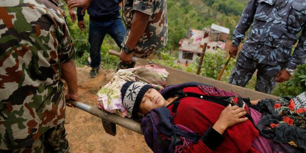 A woman with injuries from Saturday's massive earthquake, is carried by Nepalese soldiers as she arrives by helicopter from the heavily-damaged Ranachour village at a landing zone in the town of Gorkha, Nepal, Tuesday, April 28, 2015. Helicopters crisscrossed the skies above the high mountains of Gorkha district on Tuesday near the epicenter of the weekend earthquake, ferrying the injured to clinics, and taking emergency supplies back to remote villages devastated by the disaster. (AP Photo/Wally Santana)