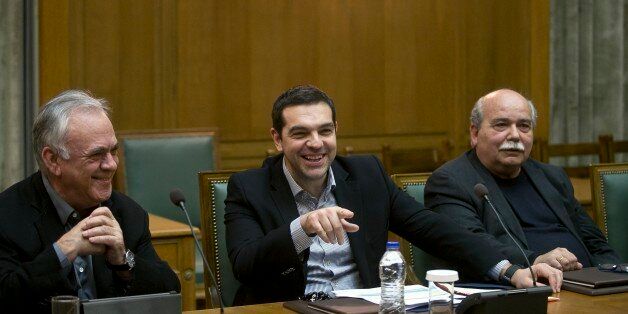 Greek Prime Minister Alexis Tsipras, center, jokes with ministers next to Deputy Prime Minister Giannis Dragasakis, left, and Minister of Interior and Administrative Reconstruction Nikos Voutsis during a cabinet meeting in Athens, on Sunday, March 29, 2015. (AP Photo/Petros Giannakouris)