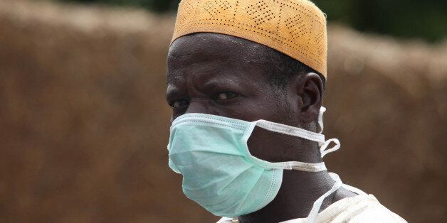 A local health worker wears a mask as he removes earth contaminated by lead from a family compound in the village of Dareta in Gusau, Nigeria Thursday, June 10, 2010. Foreign health workers and local volunteers are working to clean up villages affected by lead poisoning, after 160 people died and hundreds more fell sick. At least six villages remain contaminated with the lead, released during illegal, but highly profitable gold mining in the poor region. (AP Photo/Sunday Alamba)