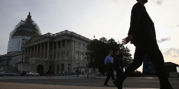 WASHINGTON, DC - MARCH 26: People walk past the U.S. Capitol Building, where the Senate is working late into the evening before leaving on a two week break March 26, 2015 in Washington, DC. The Senate is voting on a range of amendments to the budget proposal and are expected to vote on final passage of a budget later this evening. (Photo by Mark Wilson/Getty Images)