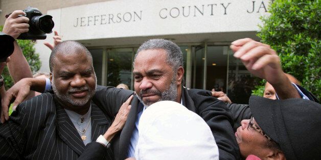 Friend Lester Bailey, left, and others greet Anthony Ray Hinton, center, as Hinton leaves the Jefferson County jail, Friday, April 3, 2015, in Birmingham, Ala. Hinton spent nearly 30 years on Alabama's death row, and was set free Friday after prosecutors told a judge they won't re-try him for the 1985 slayings of two fast-food managers. (AP Photo/ Hal Yeager)