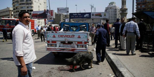 Security personnel use a bomb-sniffing dog at the scene of an explosion that killed at least one person on a bridge over the Nile River, near an upscale neighborhood of Cairo, Egypt, Sunday, April 5, 2015. Attacks mainly targeting Egyptian security forces have spiked since the 2013 military overthrow of Islamist President Mohammed Morsi following massive protests against his divisive rule. (AP Photo/Hassan Ammar)
