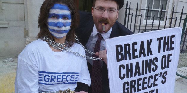 Campaigners from Jubilee Debt Campaign UK dressed as bankers hold Greece in chains outside the European Commission in London to demand debt cancellation for Greece not bailouts for banks, 20 February 2012.Photo: Jonathan Stevenson/Jubilee Debt Campaign, tel +44 (0)20 7324 4722, media@jubileedebt.org.uk