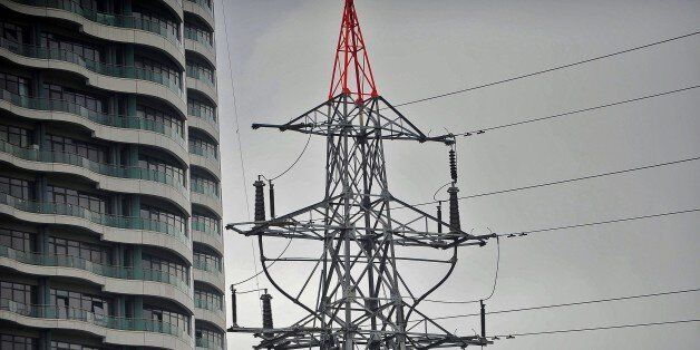 This picture shows an electrical pylon standing beside a building in Istanbul on March 31, 2015, during a massive power outage. A massive power cut caused chaos across Turkey, shutting down the metro networks in Istanbul and the capital Ankara, with the government saying an outside attack on the system was not ruled out. AFP PHOTO/OZAN KOSE (Photo credit should read OZAN KOSE/AFP/Getty Images)