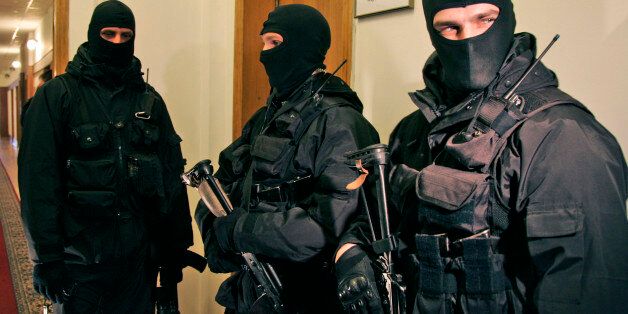 Ukrainian national security service armed agents wearing masks raid the headquarters of the country's natural gas company, Naftogaz, in Kiev, Ukraine, Wednesday, March 4, 2009. The raid by armed agents was in connection with a criminal investigation launched this week into the alleged diversion of gas worth around 7.4 billion hryvna ($900 million), SBU national security service spokeswoman Marina Ostapenko told The Associated Press. (AP Photo/Efrem Lukatsky)