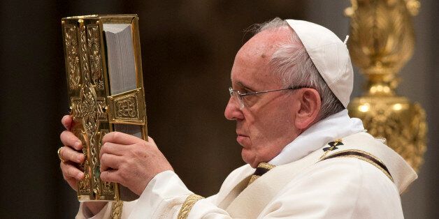 Pope Francis holds the Holy Book as he celebrates an Easter vigil service, in St. Peter's Basilica, at the Vatican, Saturday, April 4, 2015. (AP Photo/Andrew Medichini)