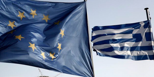 A Greek and a European Union flag billow in the wind as the ruins of the fifth century BC Parthenon temple is seen in the background on the Acropolis hill, in Athens, Friday, Jan. 23, 2015. Prime Minister Antonis Samaras' New Democracy party has failed so far to overcome a gap in opinion polls with the anti-bailout Syriza party ahead of the Jan. 25 general election. (AP Photo/Petros Giannakouris)